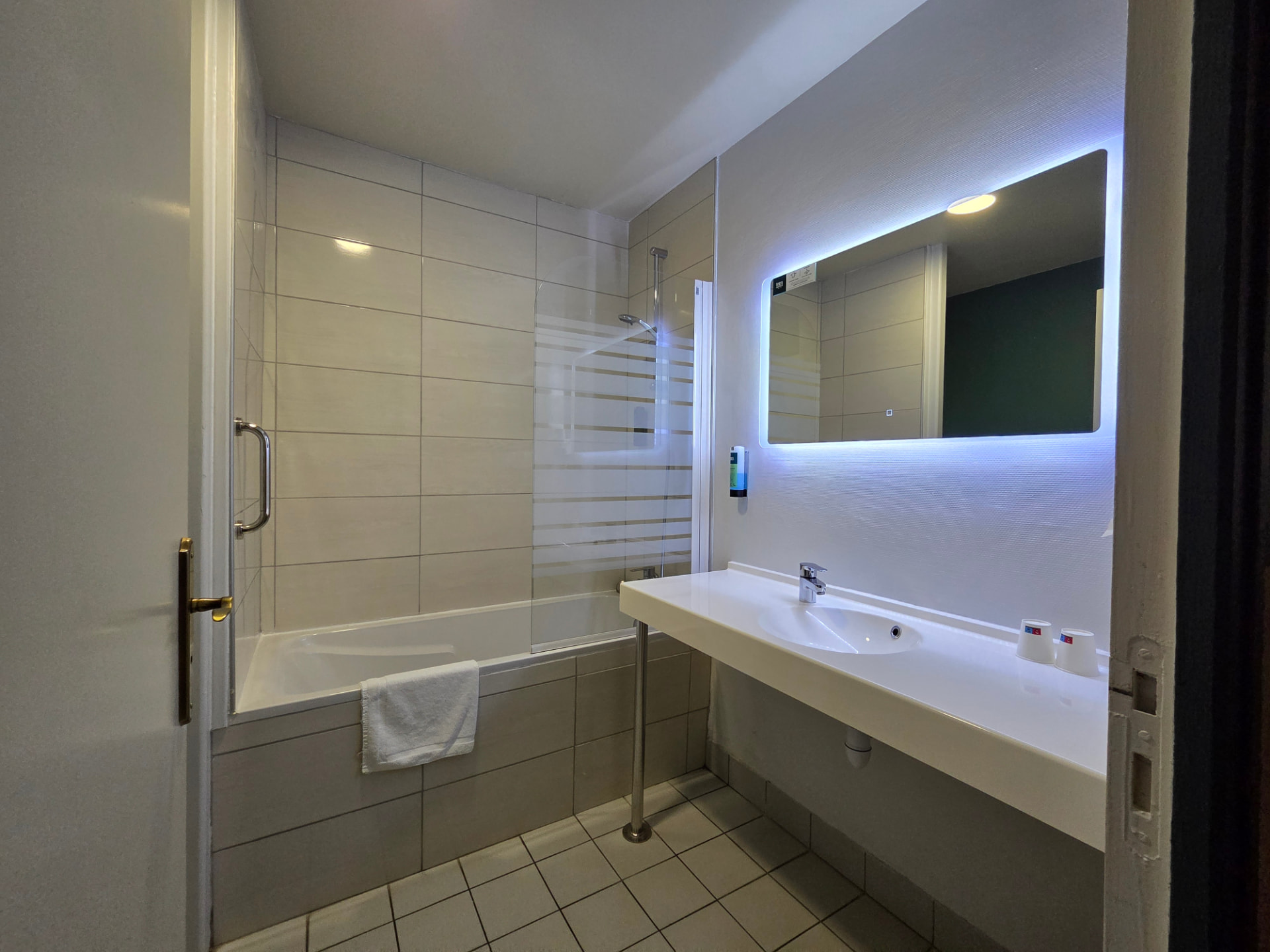 Salle de bains privative avec baignoire et grand miroir